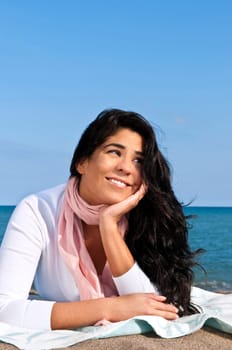 Portrait of beautiful smiling native american girl laying at beach
