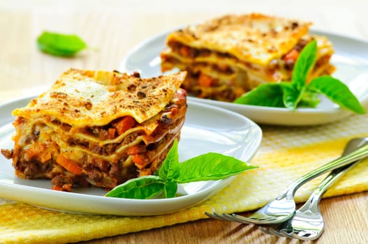 Two servings of fresh baked lasagna on plates