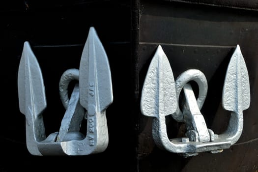 Pair of silver anchors on black background