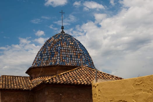 Old churches colored tile roof against blue sky