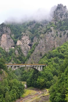 suspension bridge and a mountain in clouds