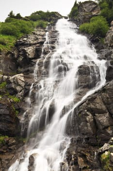 a beautiful waterfall on a mountain slope