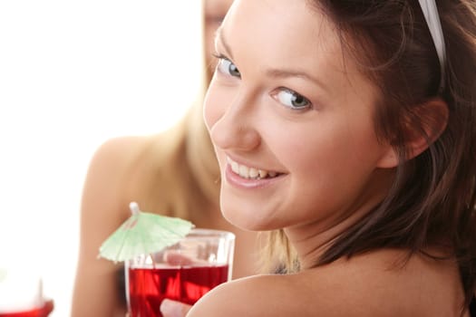 Two girlfriends in bikini, with drinks, talking