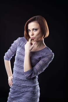 Young beauty brunette posing in grey dress on dark
