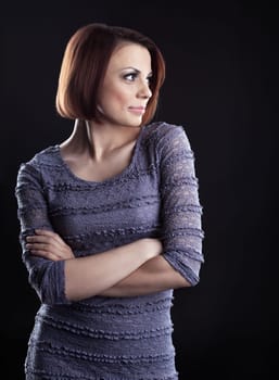 Young beauty brunette posing in grey dress on dark