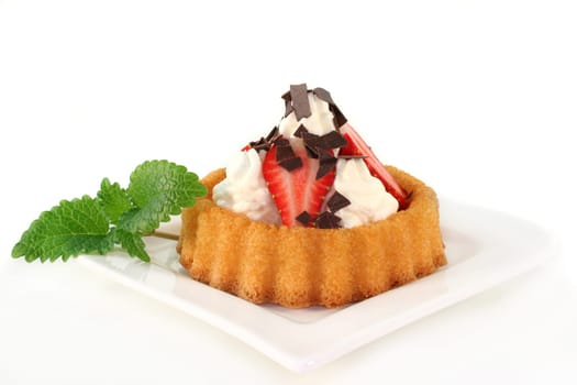 Strawberry tartlets with cream and chocolate sprinkles