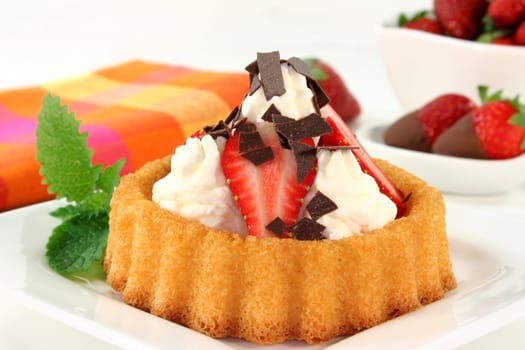 Strawberry tartlets with cream and chocolate sprinkles