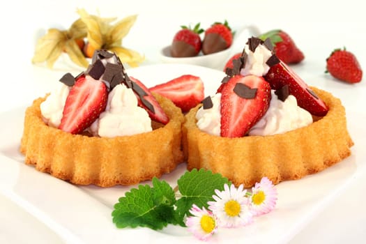 Strawberry tartlets with cream and chocolate sprinkles