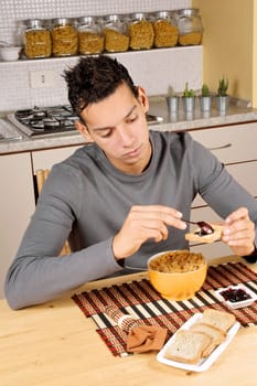 Young brazilian man having breakfast in the kitchen at home.