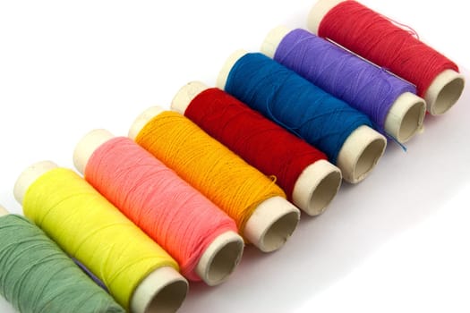 Colored thread spool on white background