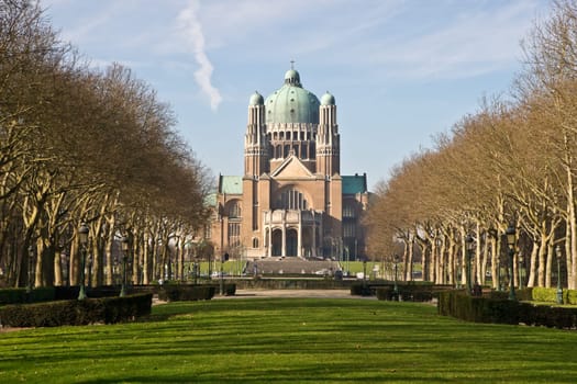 The Basilica of the Sacred Heart in Brussels ranks fifth among the largest churches in the world. The large Art Deco building lies at the end of a park way and is surrounded by trees.
