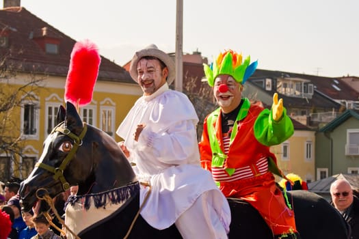VILLACH,AUSTRIA - MARCH 5,2011: Clowns riding a horse took the street at the annual carnival procession held on March 5,2011 in Villach,Austria. Participants come from Austria,Italy and Slovenia.