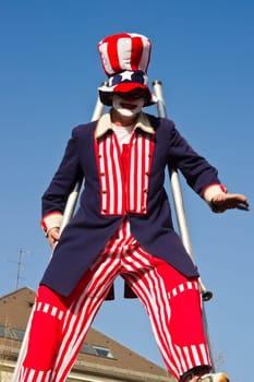 VILLACH,AUSTRIA - MARCH 5: A clown on stilts took the street at the annual carnival procession held on Mar. 5,2011 in Villach,Austria. Participants come from Austria,Italy and Slovenia.
