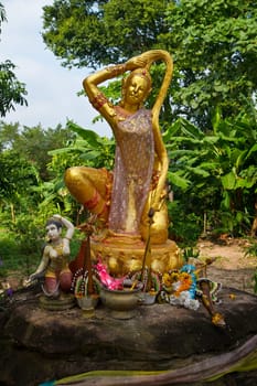 Phra Mae Thorani,the buddhist godness of earth - a statue in a remote temple area in Isaan region of Thailand