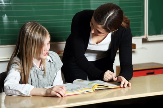 Students and teachers learning at school in the classroom in front of the blackboard