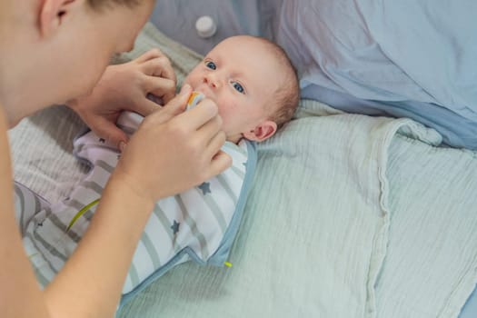 A mother carefully gives her newborn baby colic drops, ensuring comfort and relief. A tender moment of caregiving, love, and parental responsibility, symbolizing infant care and maternal dedication.