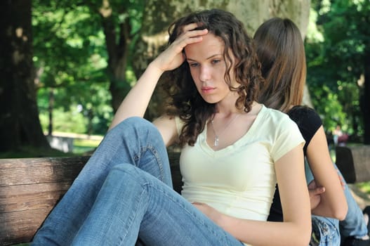 Friends outdoors series - two teenage girls are in conflick and do not speak with each another