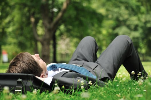 Senior people series - mature business man lying on grass and relaxing in green park
