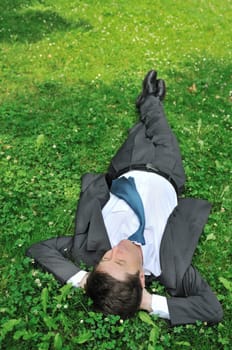 Senior people series - mature business man lying in green grass and relaxing