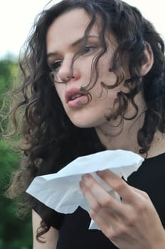 Young person (crying teenage girl) depressed in grief mood holding tissue