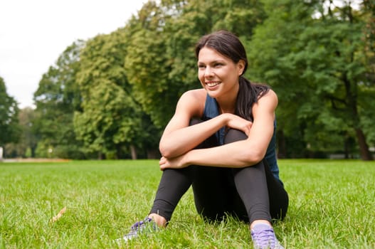 Relax - sportswoman sitting in grass