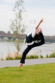 Woman in gymnastics jump outdoors