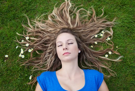 Sleeping beauty with her hair spread out on grass