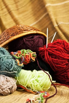 Balls of colored yarn for hand knitting in a decorative basket