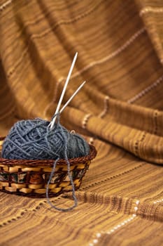 Balls of colored yarn for hand knitting in a decorative basket