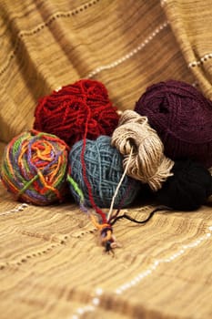 Balls of colored yarn for hand knitting on decorative tablecloth