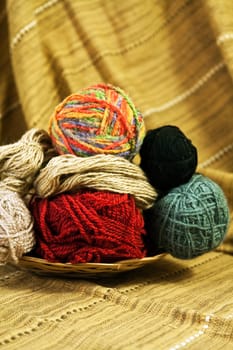 Balls of colored yarn for hand knitting in a decorative basket