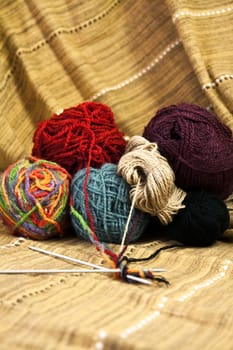 Balls of colored yarn for hand knitting on decorative tablecloth