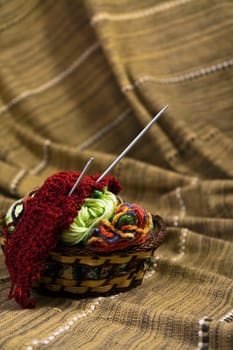 Balls of colored yarn for hand knitting in a decorative basket