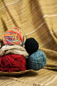 Balls of colored yarn for hand knitting in a decorative basket
