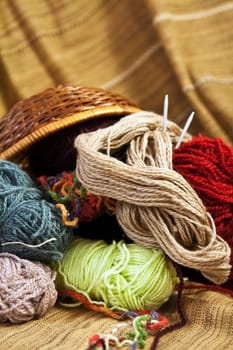 Balls of colored yarn for hand knitting in a decorative basket