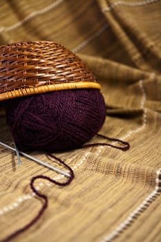Balls of colored yarn for hand knitting in a decorative basket
