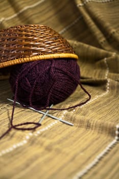 Balls of colored yarn for hand knitting in a decorative basket