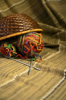 Balls of colored yarn for hand knitting in a decorative basket