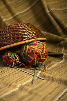 Balls of colored yarn for hand knitting in a decorative basket