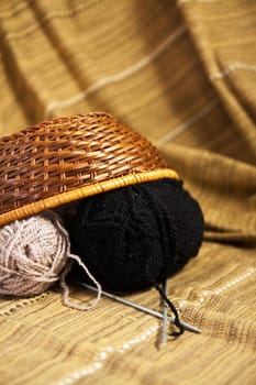 Balls of colored yarn for hand knitting in a decorative basket