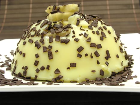 Vanilla pudding with banana slices and chocolate sprinkles
