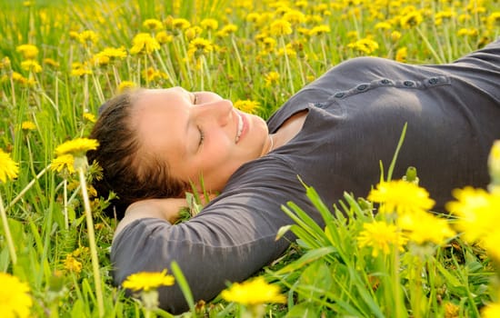 Young woman lying on a flower meadow