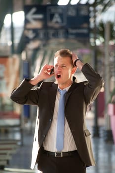Young business man angry at telephon