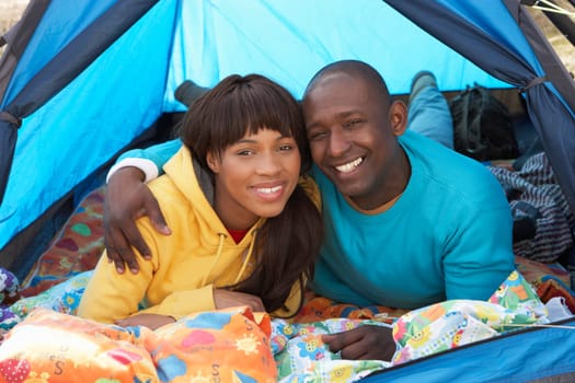 Young Couple Relaxing Inside Tent On Camping Holiday