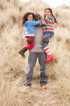 Father And Daughters Having Fun In Sand Dunes