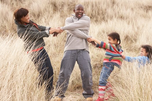 Family Having Fun In Sand Dunes