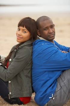 Young Couple Relaxing On Winter Beach Holiday