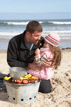 Father And Daughter Having Barbeque On Winter Beach