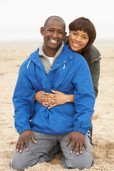 Young Couple Relaxing On Winter Beach Holiday