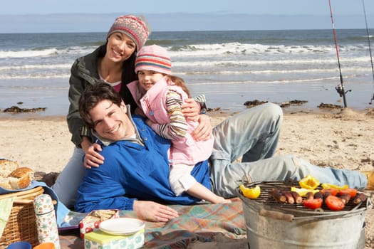 Family Having Barbeque On Winter Beach